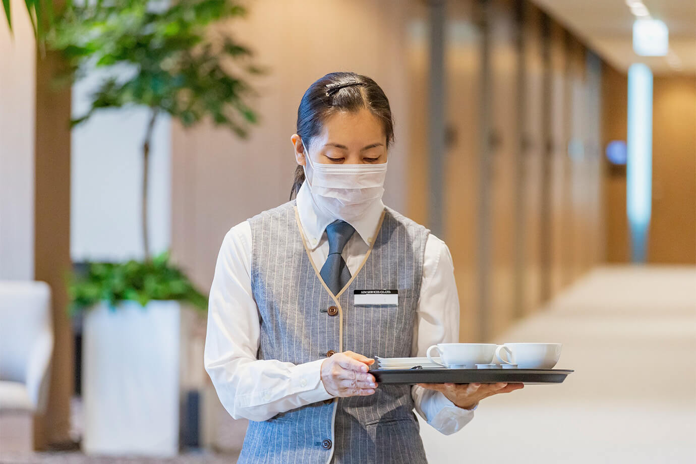 女性スタッフがお茶を運ぶ様子