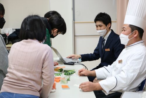 小学生が前のめりになって飾り切りを見ている様子