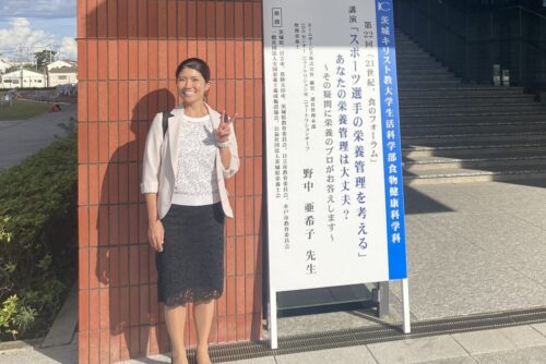 野中管理栄養士、講演看板の前で撮影