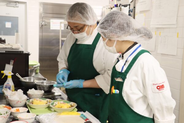 調理師と栄養士が厨房内で会話