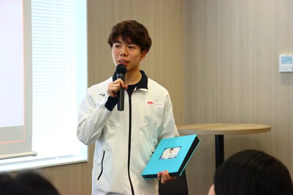 アルバムを手に持ちコメントする佐藤選手