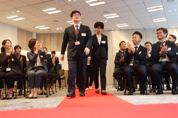 レッドカーペットを歩く社員