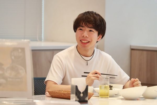 笑顔で試食する佐藤選手