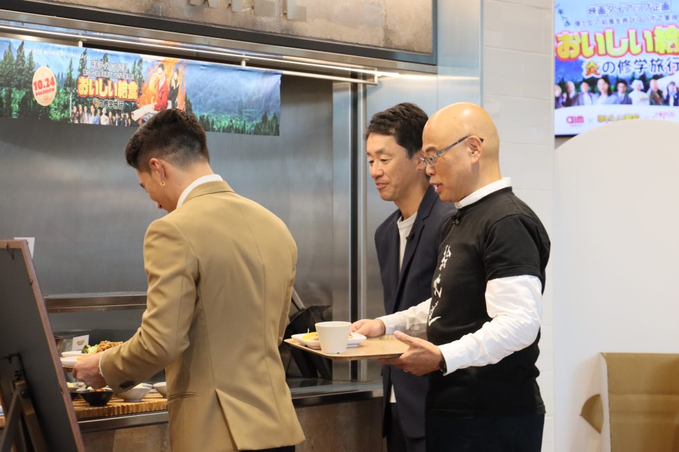 カウンターで料理を選ぶ3名